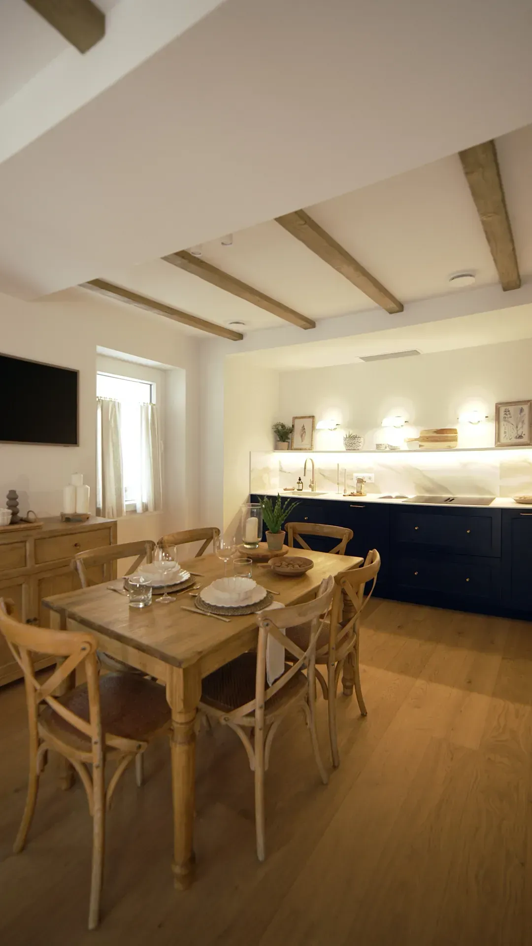 Un comedor con una mesa y sillas y una cocina al fondo.