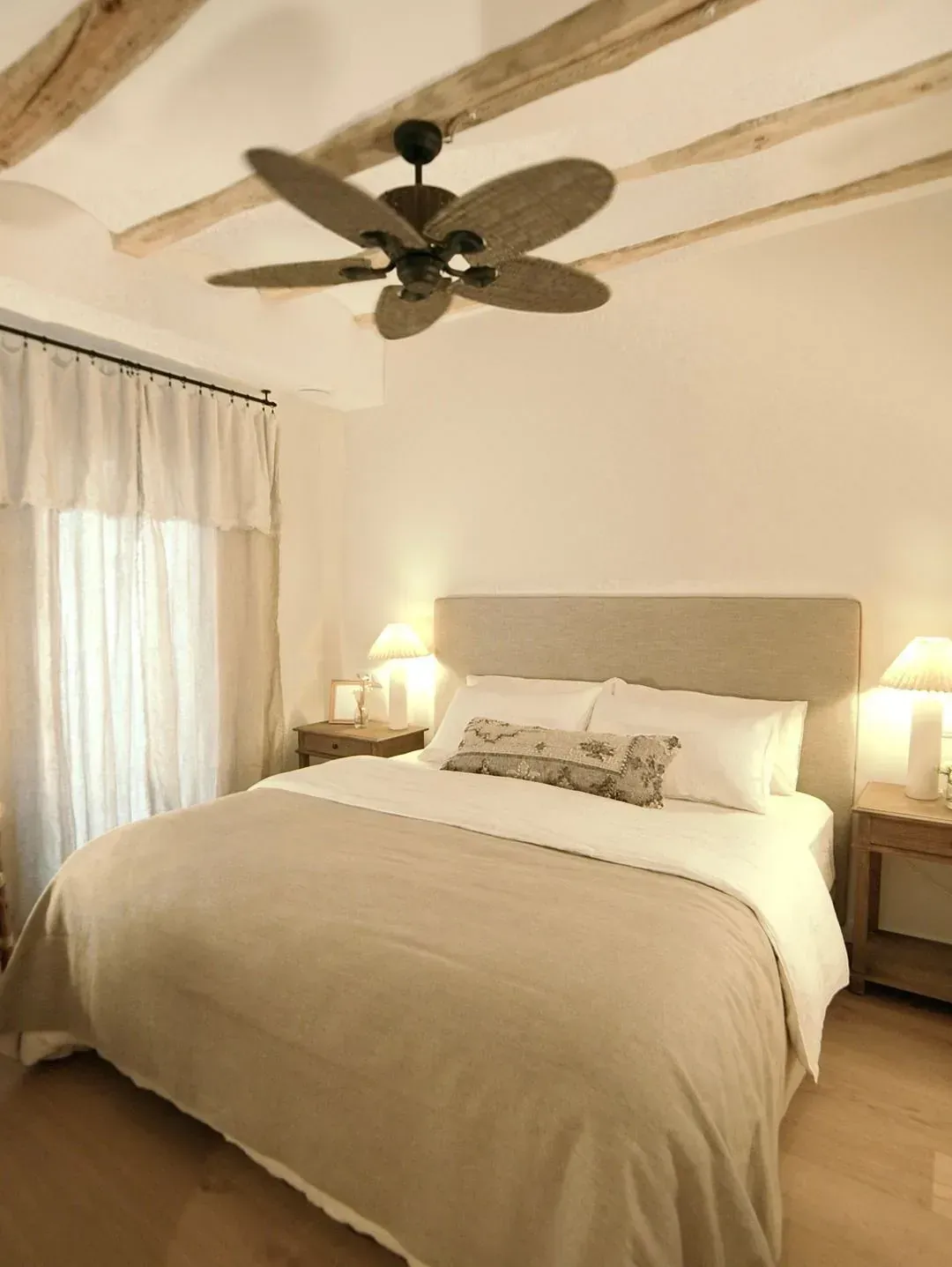 Un dormitorio con una cama y un ventilador de techo.