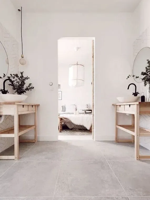 Un baño con dos lavabos y dos espejos.