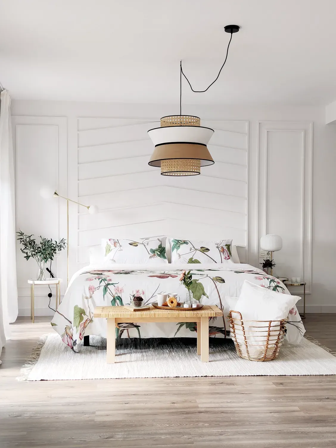 Un dormitorio con una cama, un banco, una lámpara y una cesta.