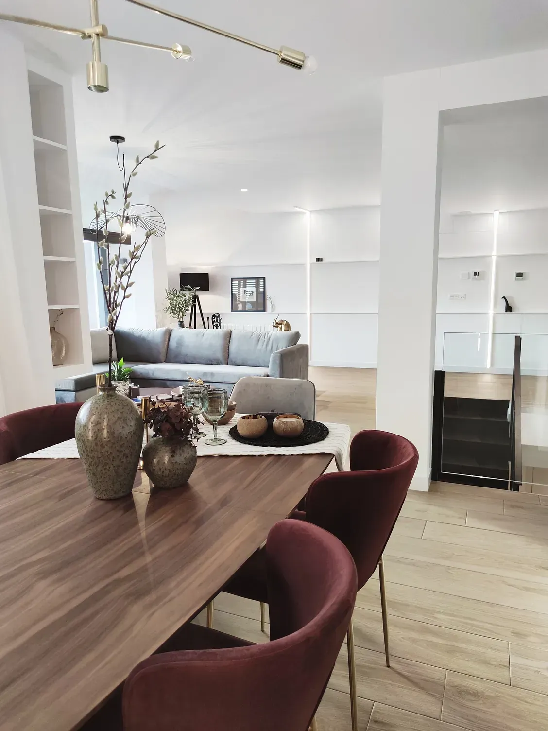 Un comedor con una mesa de madera y sillas rojas.