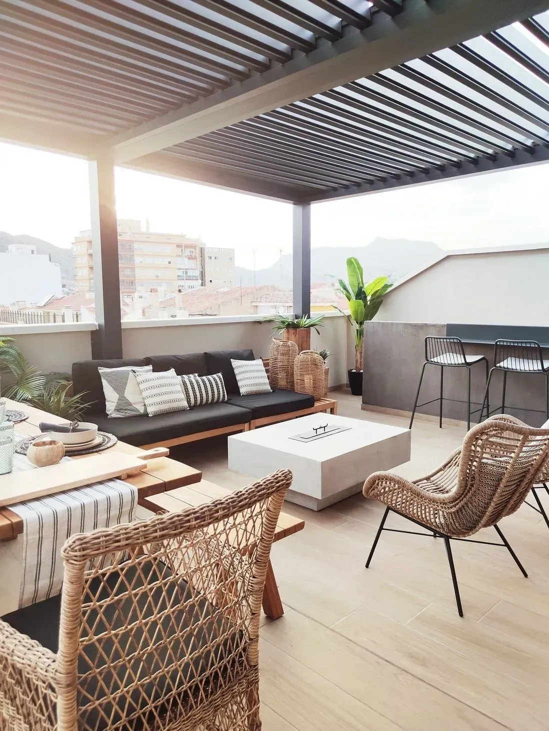 Un patio con un sofá, sillas y una mesa debajo de una pérgola.