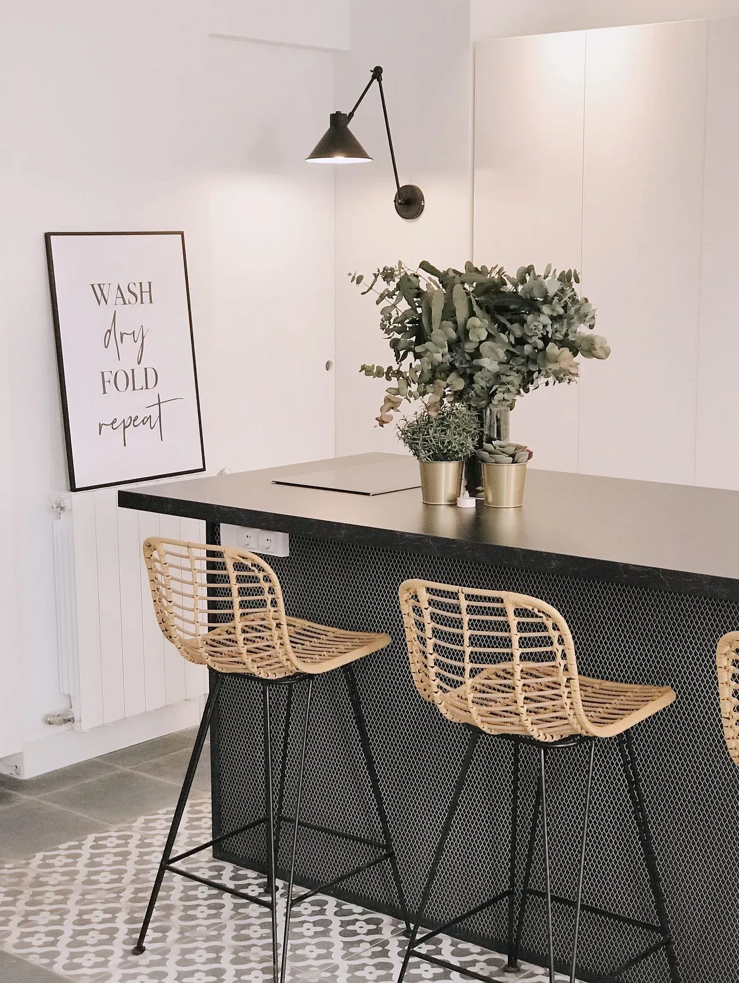 Una cocina con una mesa y sillas y un cartel que dice lavar, secar, doblar, repetir.