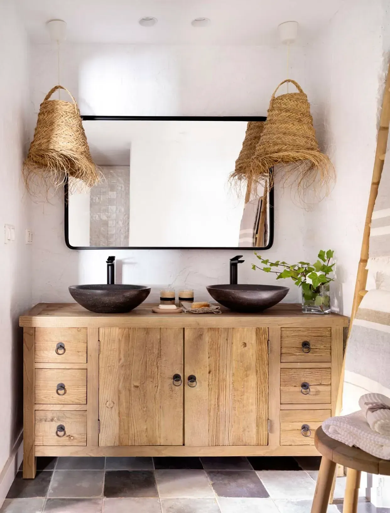 Un baño con dos lavabos, un espejo y un tocador de madera.