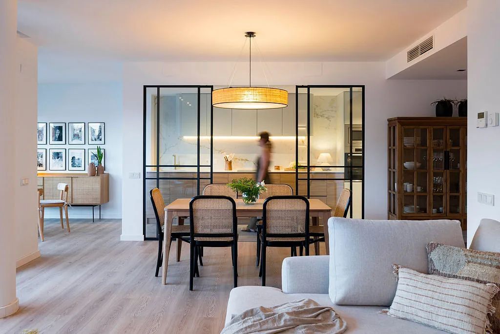 Una sala de estar con una mesa de comedor y sillas y un sofá.