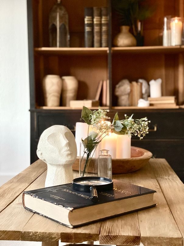 Un libro está sobre una mesa de madera delante de una estantería.