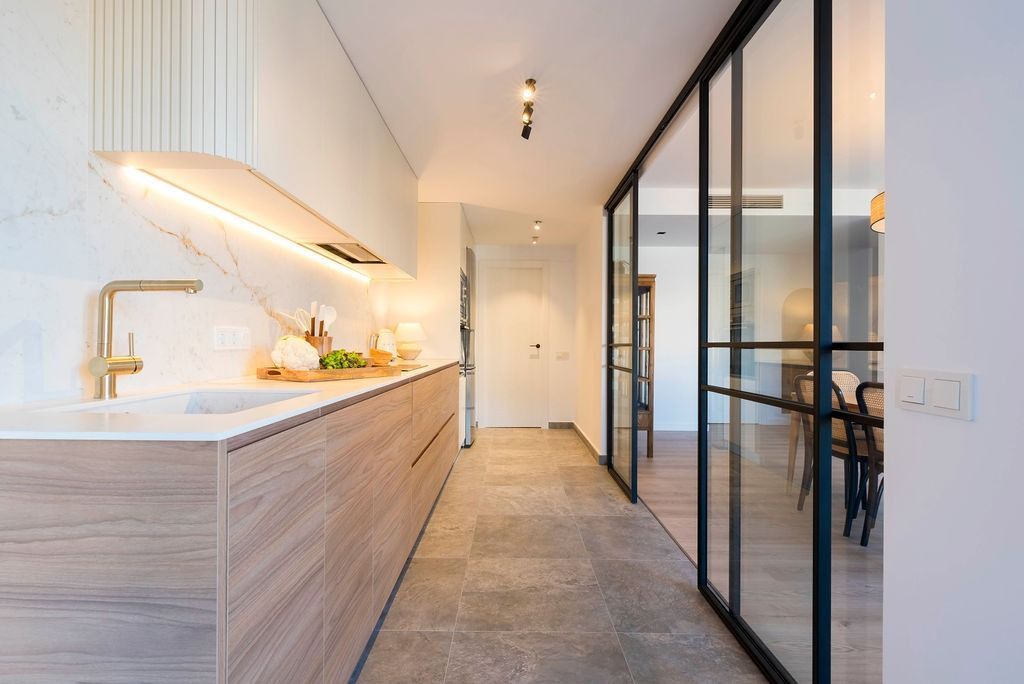 Una cocina con puertas corredizas de vidrio que conducen a un comedor.