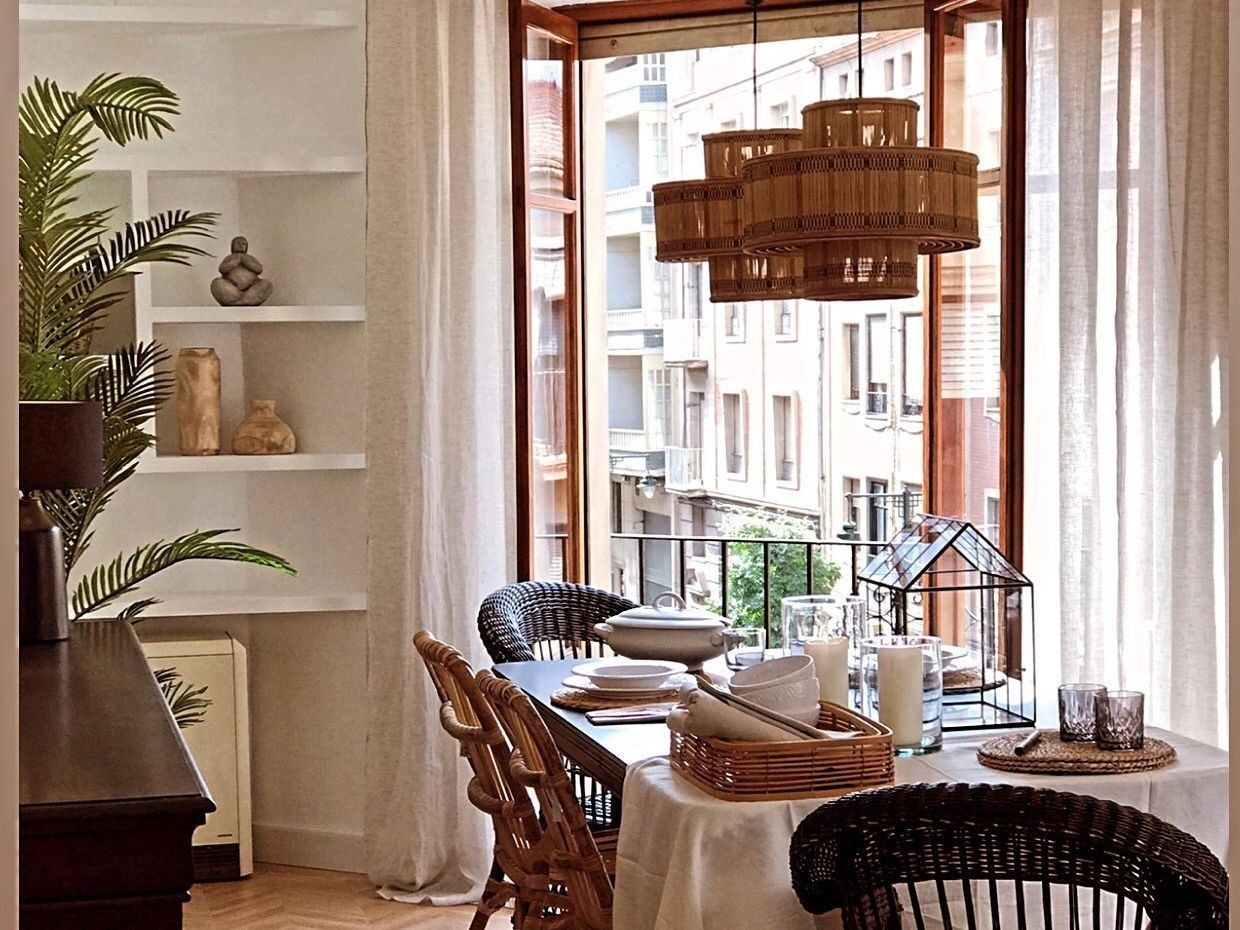 Un comedor con una mesa y sillas frente a una ventana.