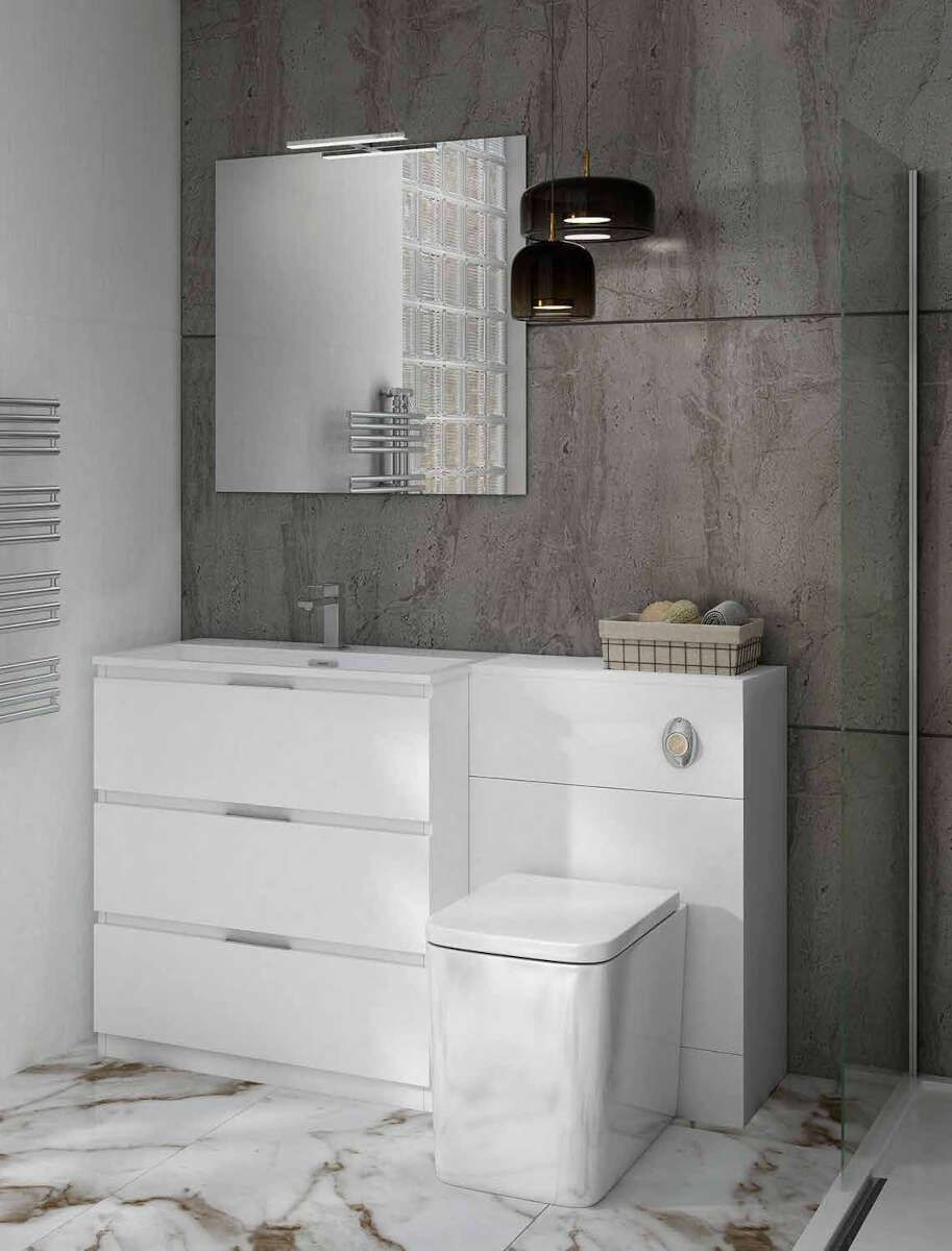 Un baño con lavabo, inodoro, espejo y toallero.