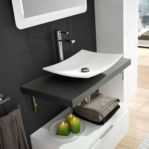 Un baño con lavabo, espejo, toallas y velas.