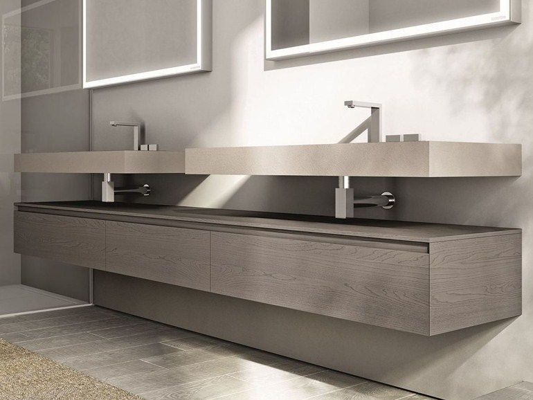 Un baño con dos lavabos y dos espejos.