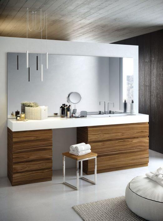 Un baño con tocador y un espejo grande.