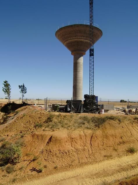 Se está construyendo una gran torre de agua en la cima de una colina de tierra.