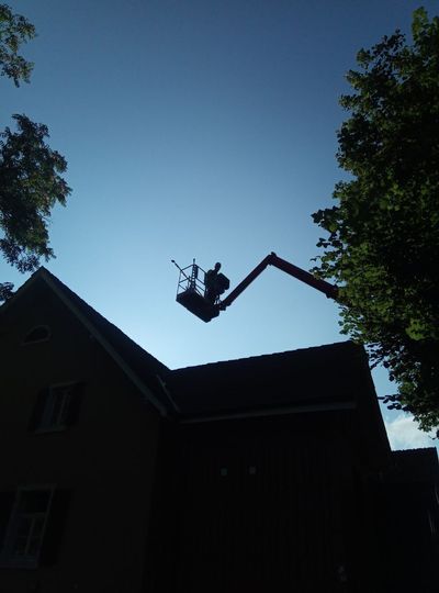 Mann auf Steildach mit Sicherung