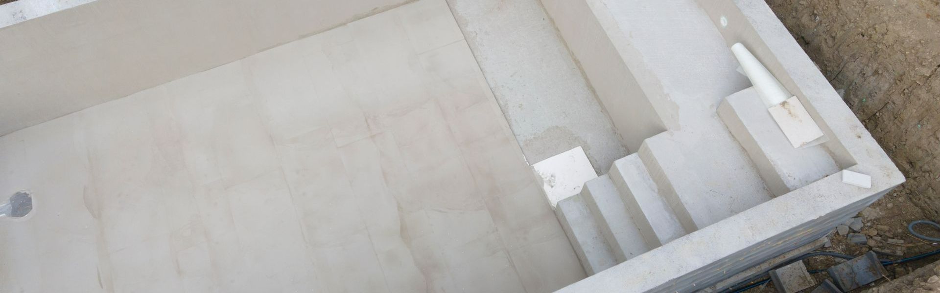 Une piscine en béton à l'aspect blanc