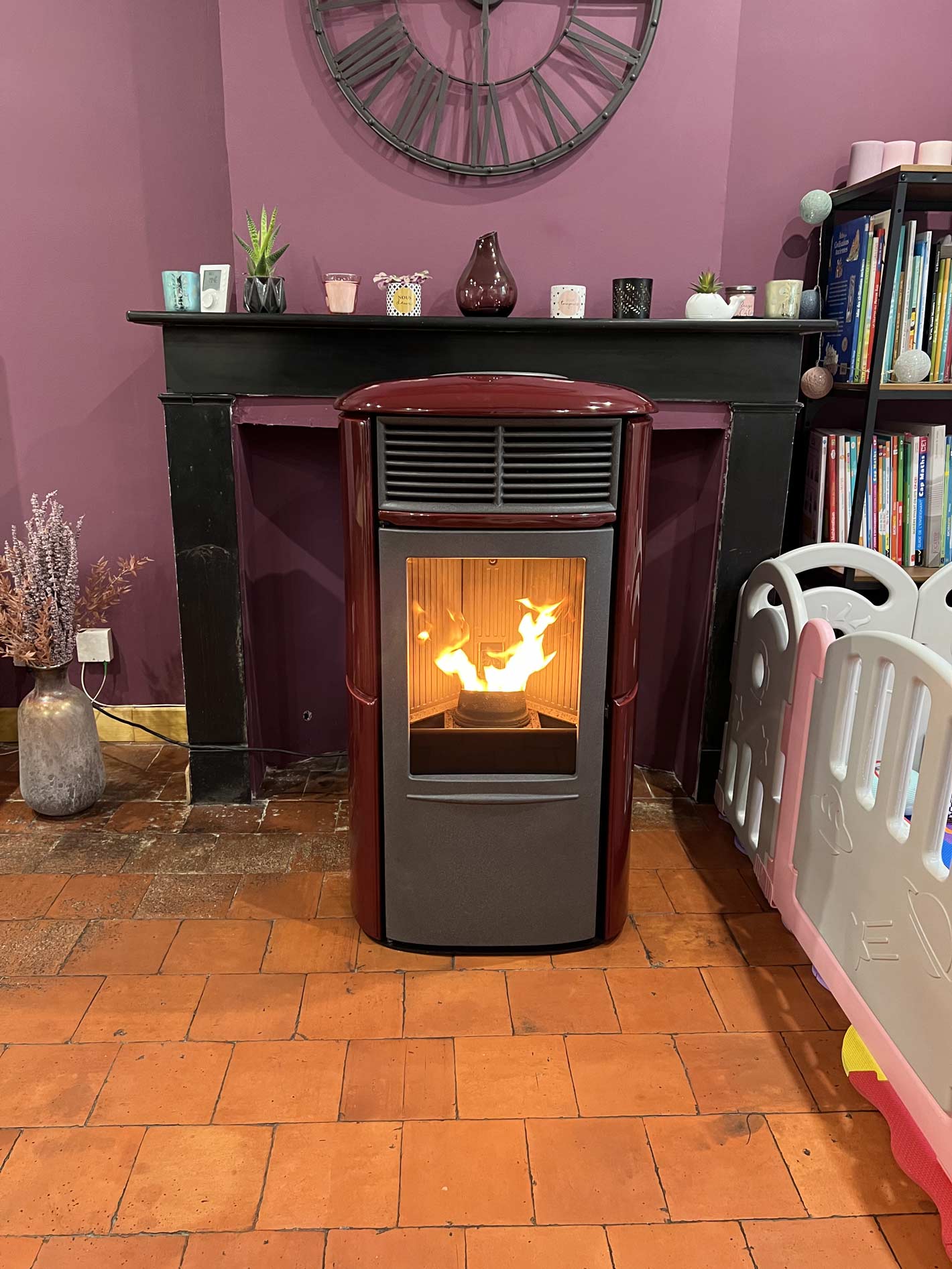 Poêle à granulés rouge et gris en fonction dans une pièce violette