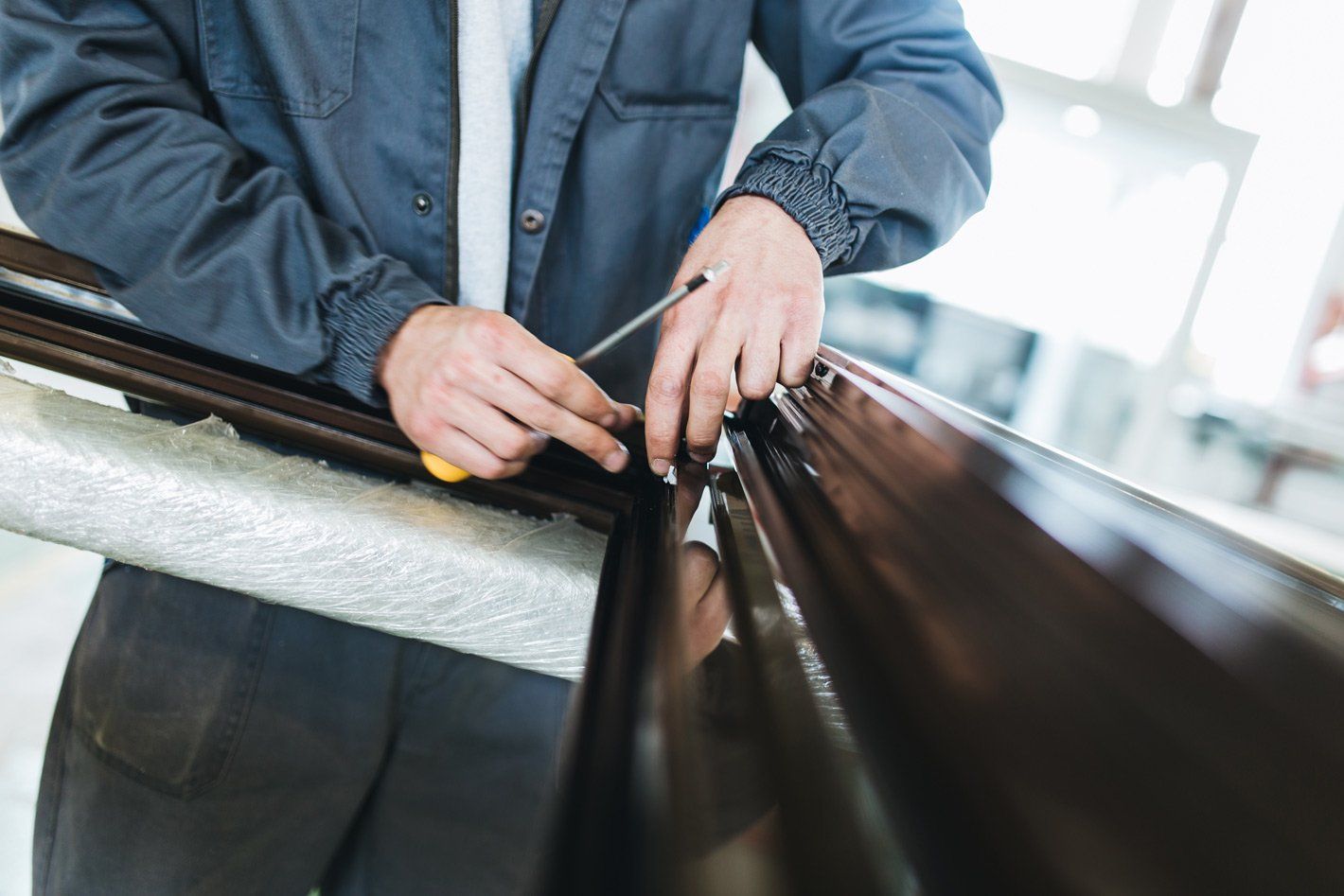 Menuisier ajustant une fenêtre noire avant sa pose