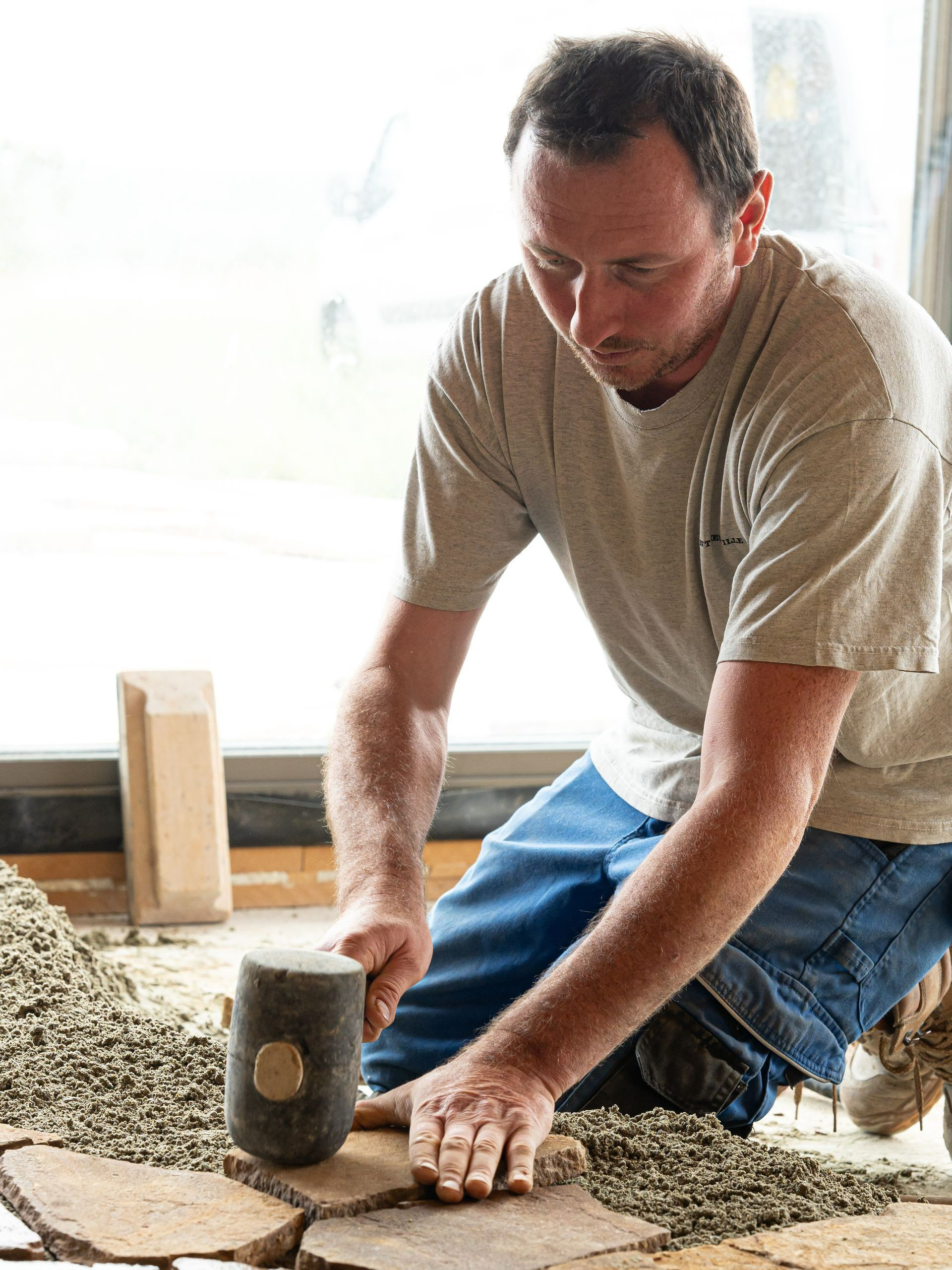 Un ouvrier pose des dalles au sol