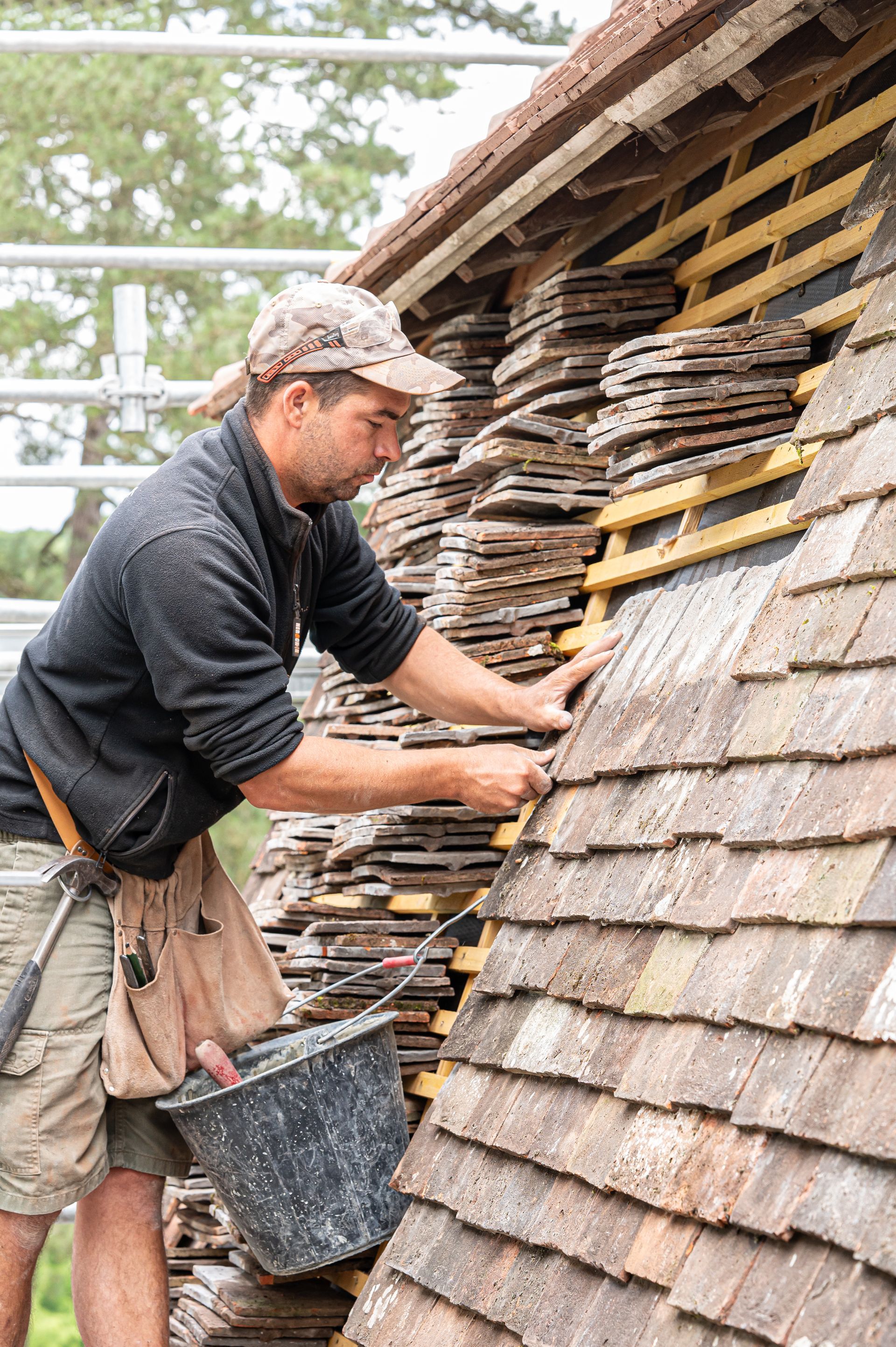 Un ouvrier réalise la couverture d'un toit