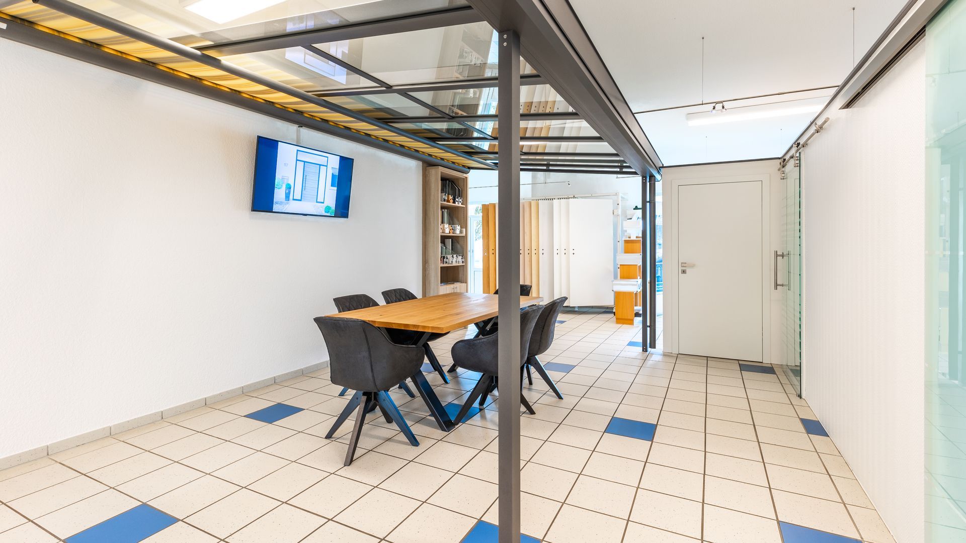 Ein großer Raum mit einem Tisch und Stühlen darin.