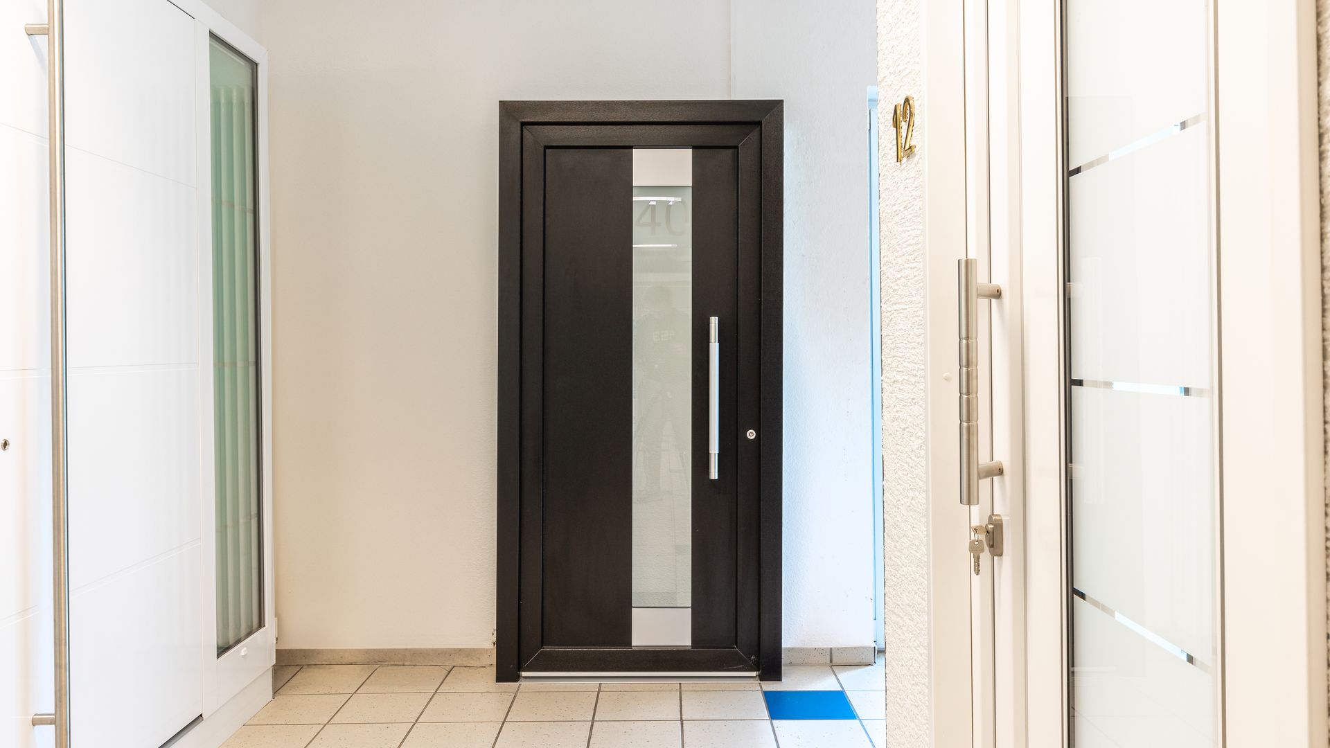 Ein Flur mit einer schwarzen und einer weißen Tür.