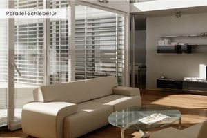 Ein Wohnzimmer mit einer Couch und einem Glastisch