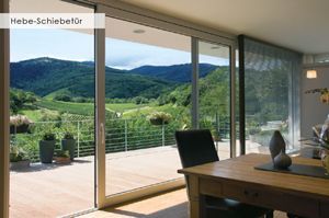 Ein Esszimmer mit Tisch und Stühlen und Blick auf die Berge