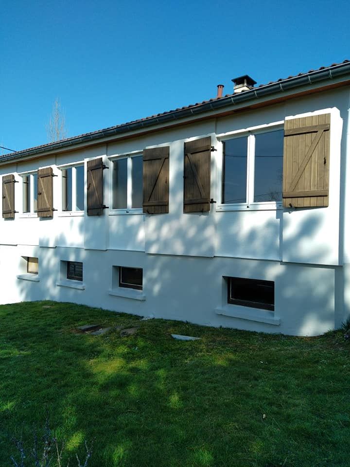 Une façade de maison avec des volets en bois.