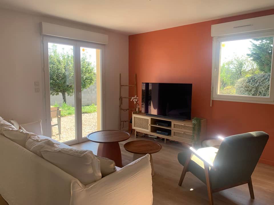 Un salon avec un mur orange.
