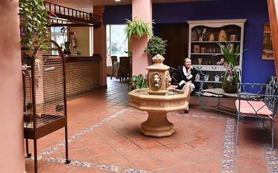 Una mujer está sentada frente a una fuente en un vestíbulo.
