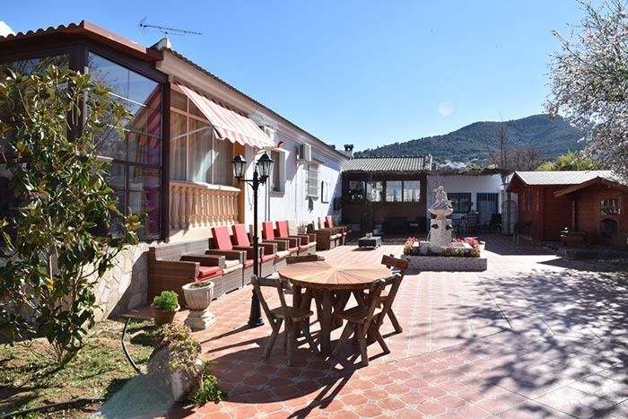Un patio con una mesa y sillas frente a una casa.