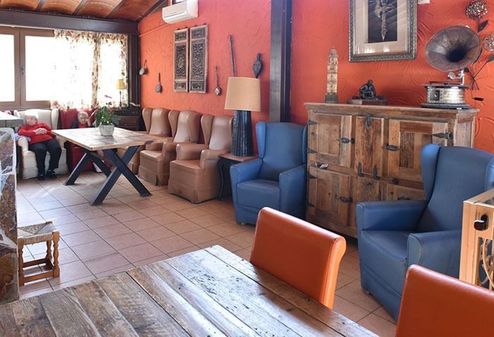 Una sala de estar con sillas azules y una mesa de madera.