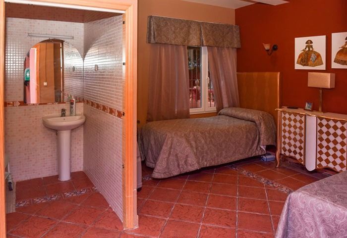 Un dormitorio con dos camas, un lavabo y un espejo.