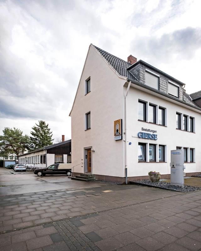 Ein weißes Gebäude mit einem Schild an der Seite, auf dem