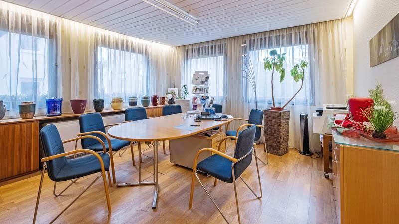 Ein Konferenzraum mit einem Tisch und Stühlen