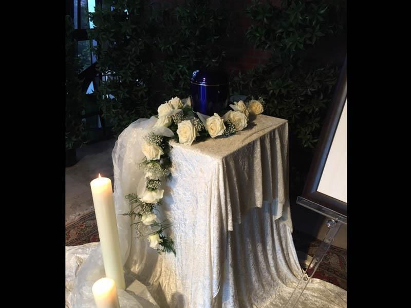 Ein Tisch mit einer Kerze und Blumen darauf