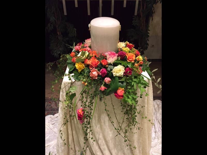 Eine Kerze ist von Blumen umgeben auf einem Tisch.