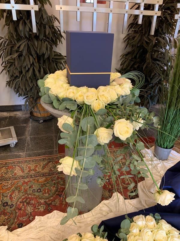 Eine Vase mit weißen Rosen steht auf einem Tisch