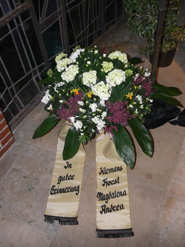 Ein Blumenkranz mit einer Schleife mit der Aufschrift „Andrea“