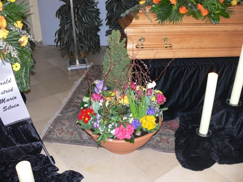 Eine Vase mit Blumen steht vor einem Sarg