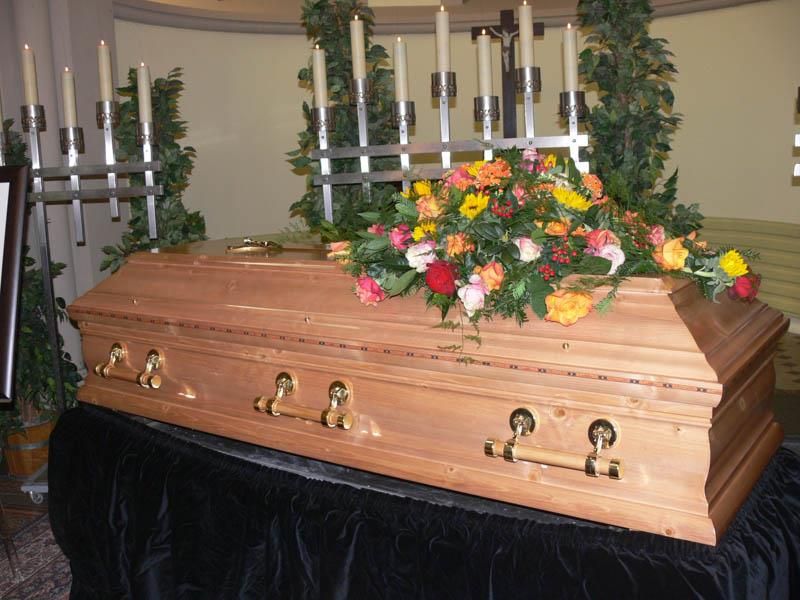 Ein Sarg mit Blumen und Kerzen darauf