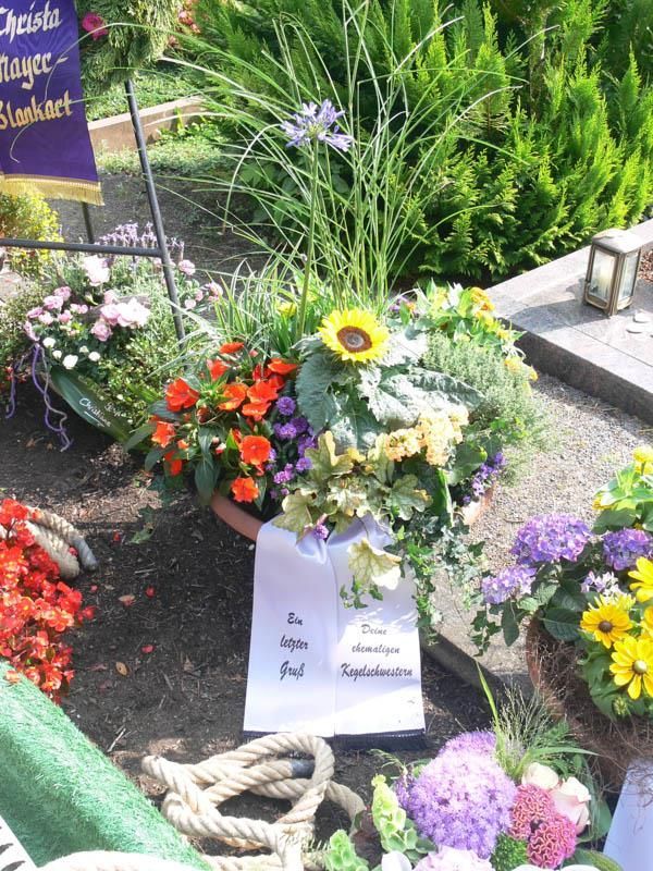 Ein Friedhof mit Blumen und einem Schild mit der Aufschrift 