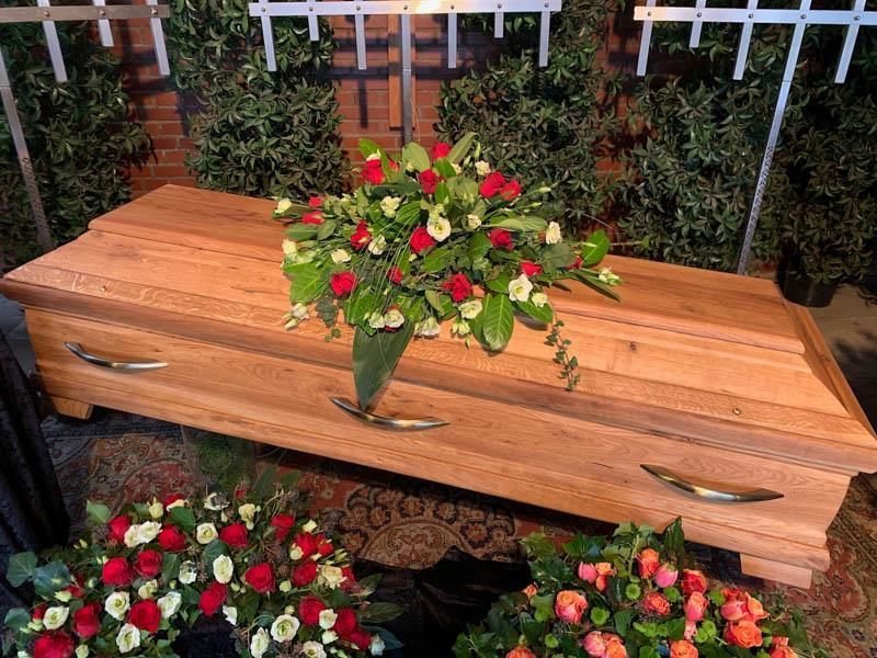 Ein Holzsarg mit Blumen darauf