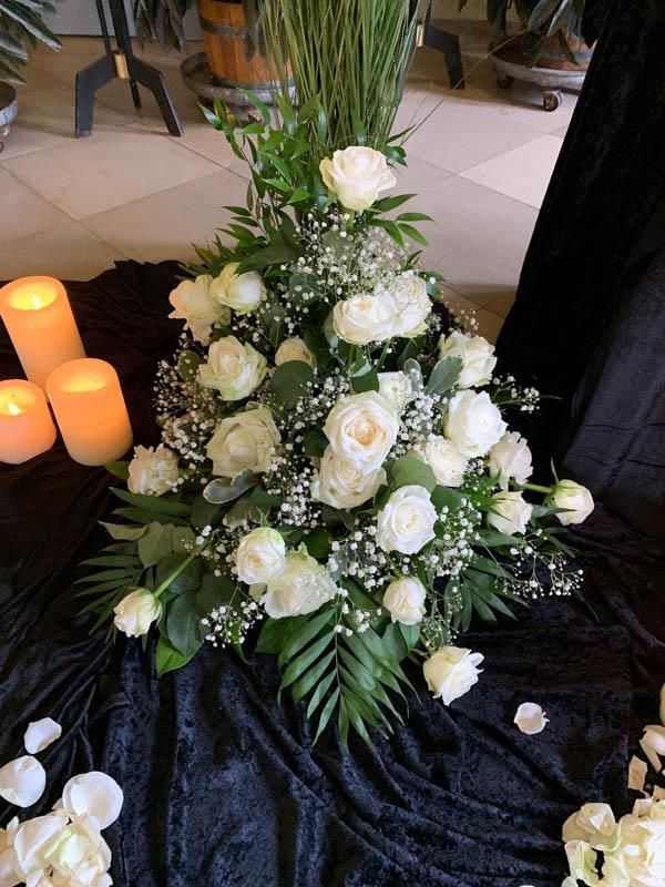 Ein Strauß weißer Blumen und Kerzen auf einem Tisch