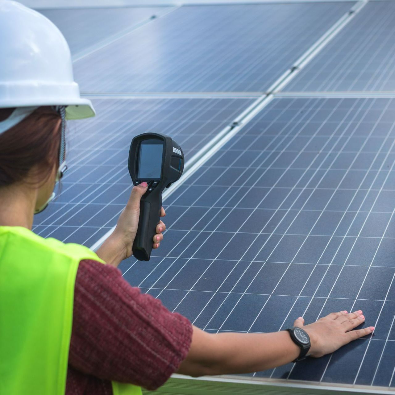 Technicienne en train de mesurer des panneaux solaires