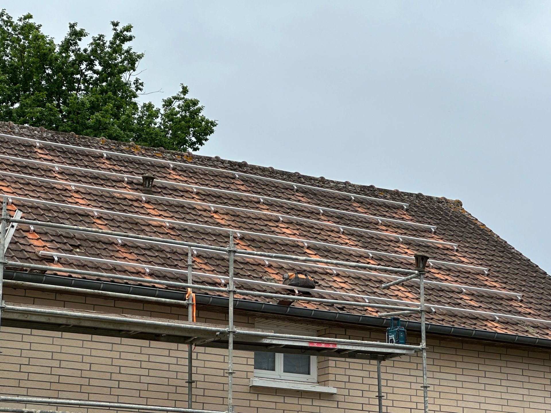 Échafaudage devant une toiture en train d'être préparée pour la pose de panneaux solaires