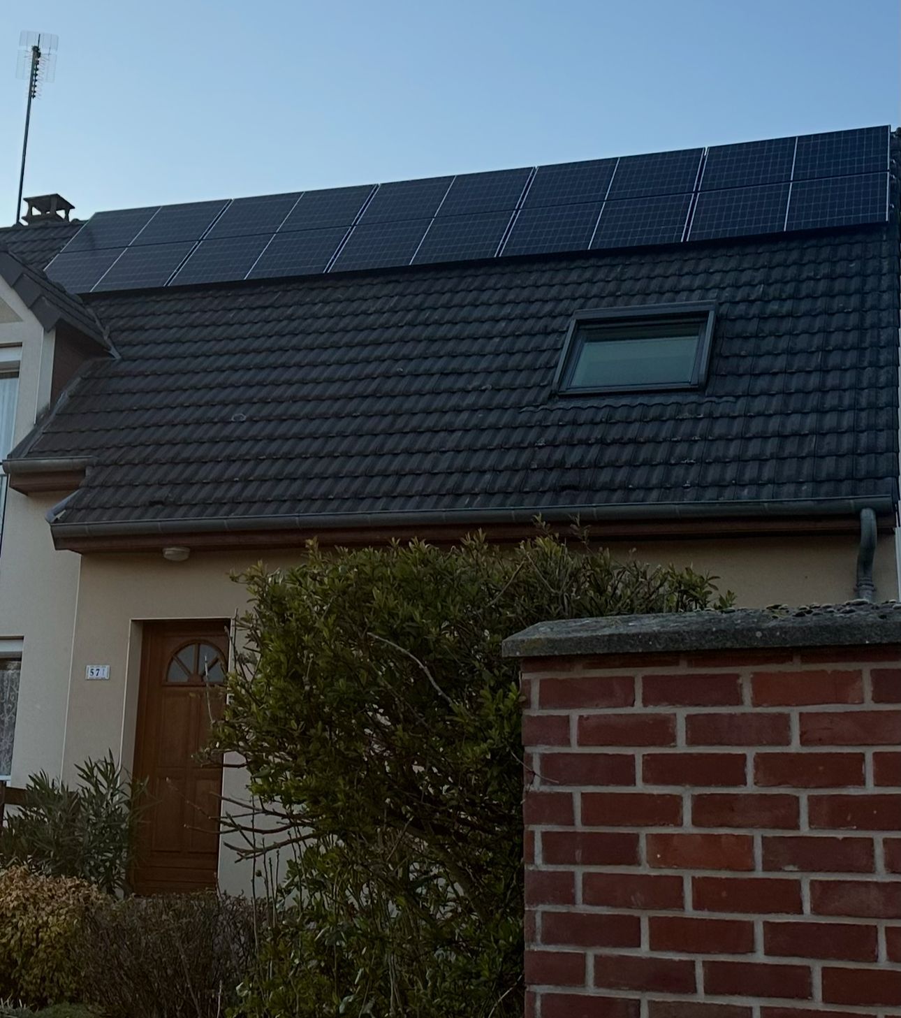 Petite maison derrière un muret de briques rouges