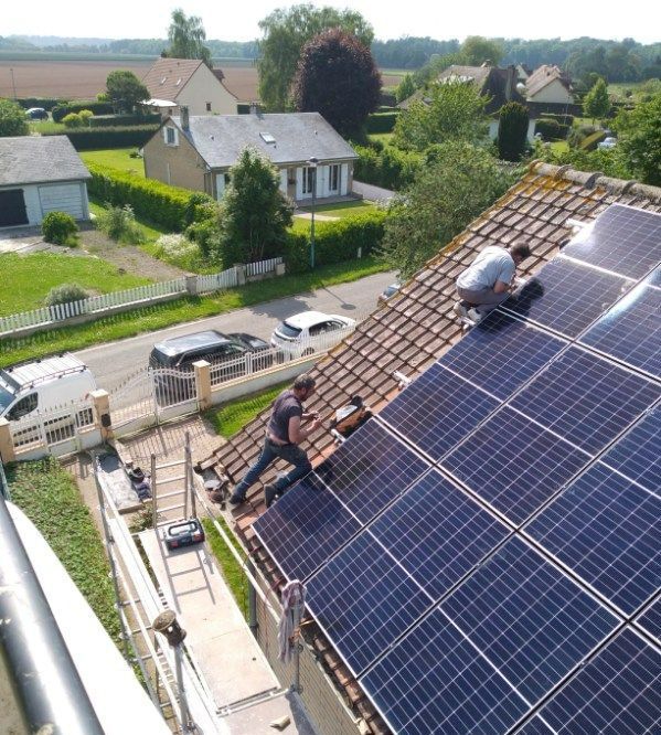 Deux hommes sur une toiture avec des panneaux solaires
