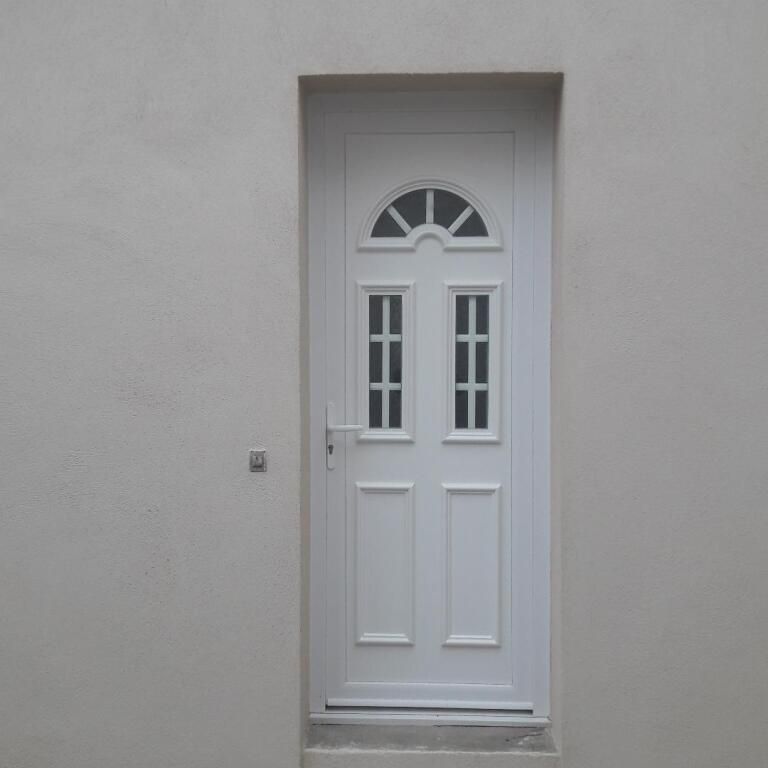 Une porte extérieure blanche à panneaux de verre.