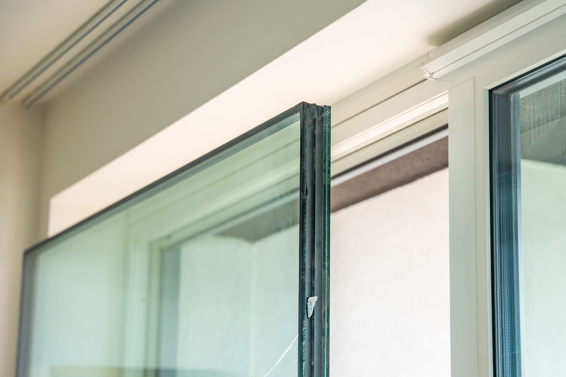 Gros plan sur l'installation d'une fenêtre à plusieurs panneaux de verre dans un cadre blanc.